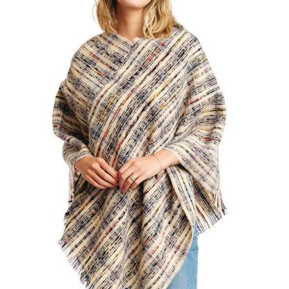 Person wearing a multicolored striped poncho on a white background